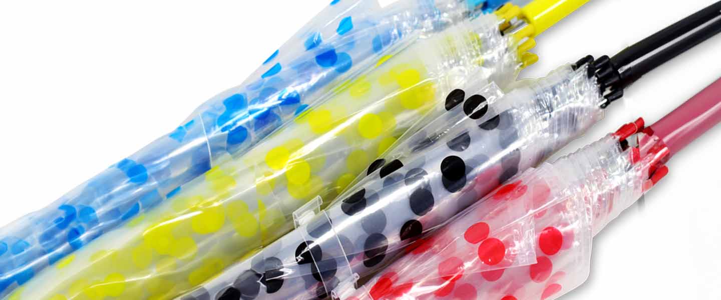 Transparent umbrellas with colorful dot patterns and black or colored handles arranged diagonally on a white background.