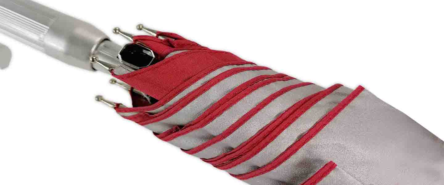 Close-up of a folded umbrella showcasing red stripes on a gray canopy.