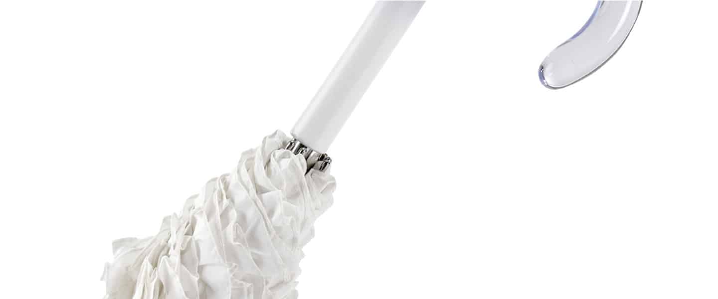 Dettaglio di un ombrello bianco con manico trasparente e struttura ondulata.